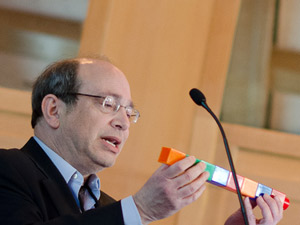 Neil Aronin uses giant Lego blocks to explain how gene silencing drugs might break down into smaller molecules with side-effects of their own. Image Credit: Lev Blumenstein for CHDI